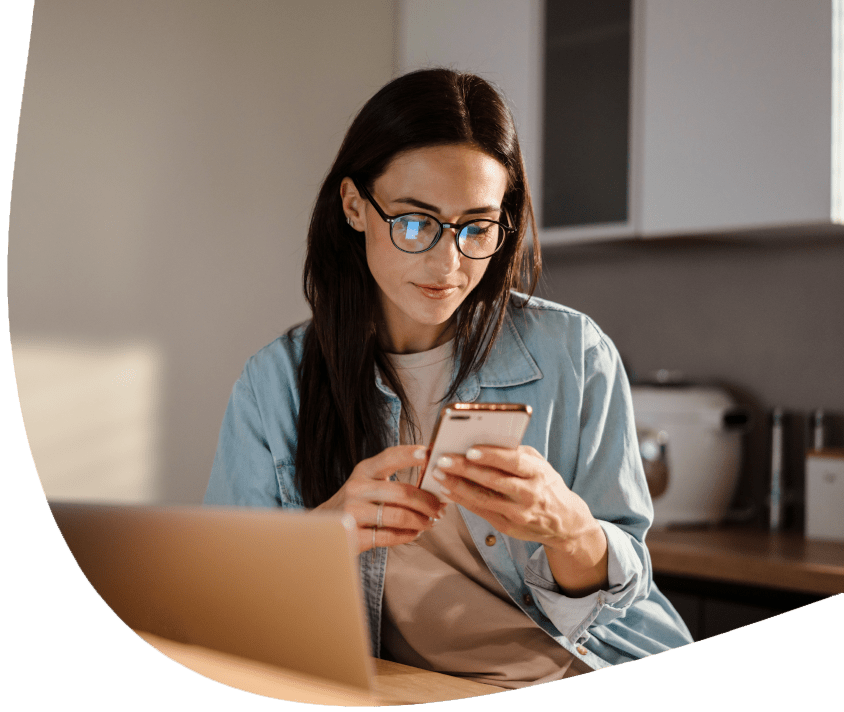 Kobieta przy biurku wpatrzona w telefon Kobieta przy biurku wpatrzona w telefon